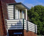 Rechter zijgevel: balkon met houten balustrade.
<br/>
Gert-Jan Lobbes, 2019